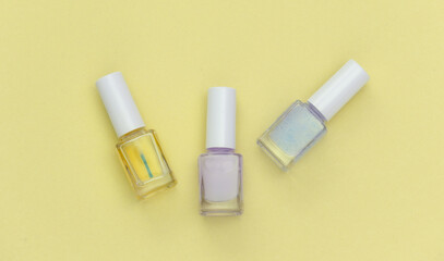 Nail polish bottle on yellow background. Beauty concept. Top view
