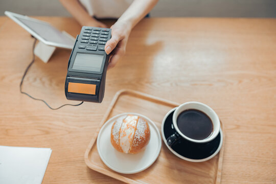 Female hand holding terminal for contactless payment
