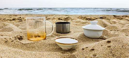 Fototapeta na wymiar Seaside. Dishes with tea on the sand. Summer vacation.