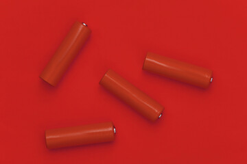 Four AA batteries on red background. Top view