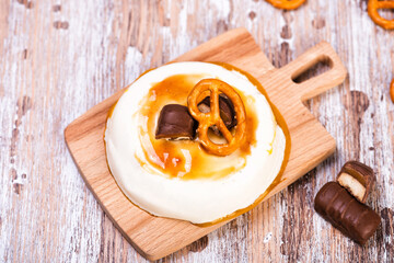 Vanilla panna cotta with caramel on wooden rustic table