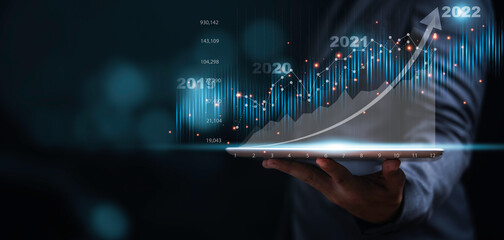 Businessman or trader showing glowing virtual technical investment graph chart for analysis stock...