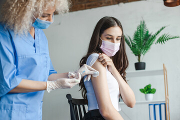 Woman getting vaccine from a doctor during immunization campaign. Influenza pandemic and medical...