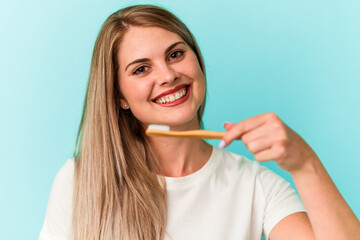Young russian woman holding a toothbrush isolated on blue background