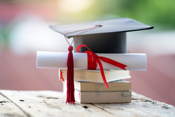 Close-up selective focus of a graduation cap or mortarboard and diploma degree certificate put on...