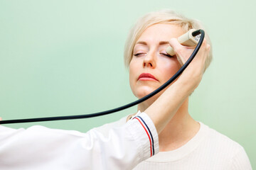 ultrasound examination of the eyes, an ultrasound scanner examines the eyes of a woman. Vision examination concept.