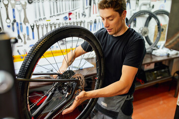 Man fixing bicycle wheel in garage
