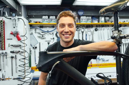 Cheerful man in bicycle repair workshop
