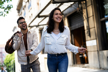 Happy young couple outdoors. Loving boyfriend and girlfriend walking in the city..