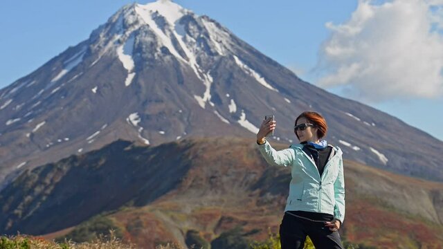 Hiking and eco tourism woman makes selfie at mountain