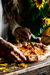 Galette with peaches. Part of galette and sunflowers in focus 