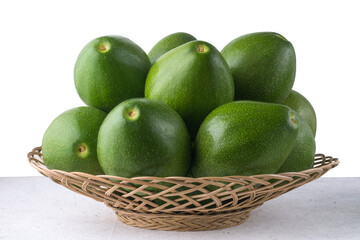 avocados in a basket, also known as alligator pear or butter fruit, fresh fruits on a white background, closeup