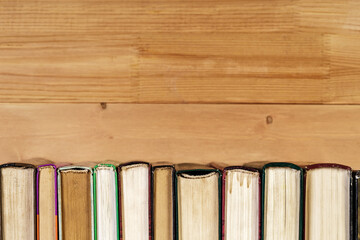 Stack of old books on a wooden shelf