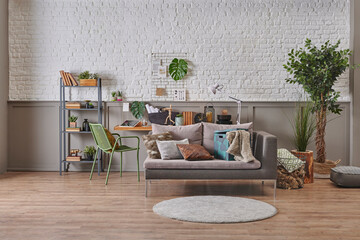 Modern grey sofa pillow decor in the room, wooden table background with home ornament and bookshelf style, white brick brown classic wall, black marble.