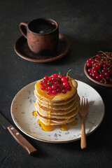 Stack of pancakes with red currants