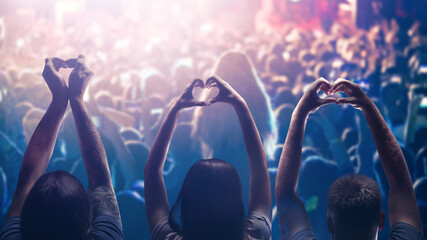 Love to music. Male and female heart shaped hands and crowd or audience at live music concert