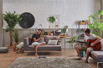 Two men working together at home, friendship, spending a good time at house, modern decoration...