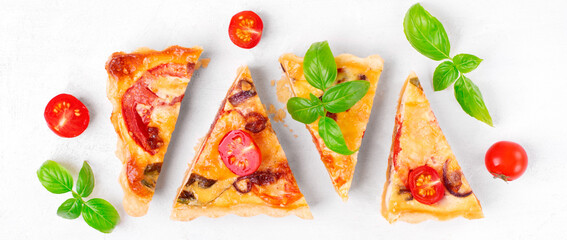 Quiche with egg, tomato, caramelized onion, basil and cheese cut into slices. French cuisine pie. Top view