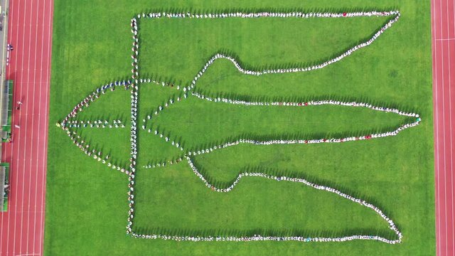 Coat of arms of Ukraine made up of people at the stadium. Aerial view, shooting from a drone. Ukraine's Independence Day. 