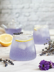 Glasses of fresh sparkling lavender-lemonade soda drink with salt&sugar on the edge of...
