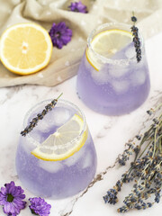 Glasses of fresh colorful sparkling lavender-lemonade drink with salt and sugar on the edge of...