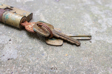 Old rusty keys in lock. Vintage door padlock with keys. Antique keys on weathered background with copy space. Security and safety concept. Aged iron key and padlock. House protection concept. 