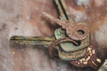 Old rusty keys in lock. Vintage door padlock with keys. Antique keys on weathered background with copy space. Security and safety concept. Aged iron key and padlock. House protection concept. 