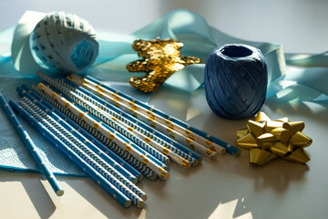 Baby showers decor. Blue and golden color straws, teddy bear, napkins, ribbons for gender reveal party, newborn baby, boy's birthday.
