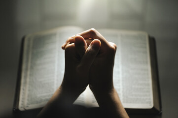Women pray from god blessing to have a better life. Women hands praying to god with the bible....