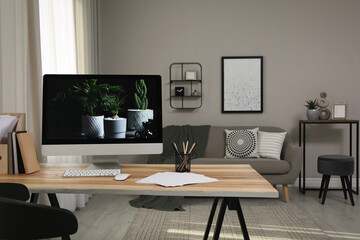 Comfortable workplace with computer on wooden desk in modern office. Interior design