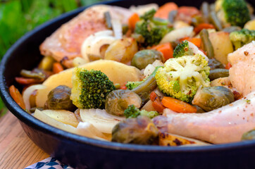 Baked vegetables with chicken leg on a baking sheet