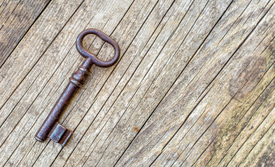 Escape room game, old iron key on wooden background