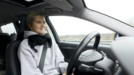 Young woman with natural look driving a passenger car on a German highway. The young woman shows various emotional reactions to the traffic event.