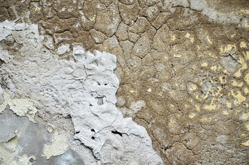 Old concrete wall with peeling plaster and cracks