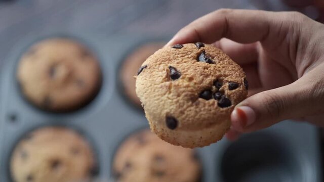women's hand breaking muffin cake close up 