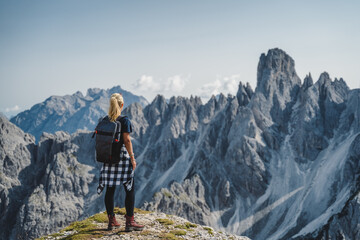 Woman hiker with backpack against Cadini di Misurina mountain group range of Italian Alps, Dolomites, Italy, Europe