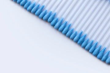 A row of cotton buds on a white background.