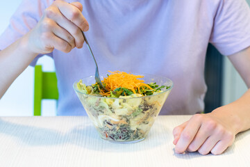 Healthy eating, dieting and people concept - close up of young woman eating vegetable mixed salad in restaurant, in dining table. Dieting concept. 