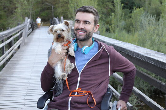 Man on a wheelchair with affectionate dog