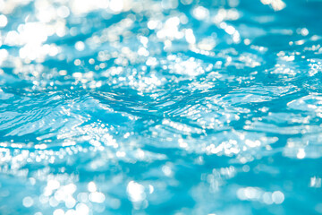 Naklejka na ściany i meble Water and air bubbles over blue background,sea wave ,Bokeh light background in the pool,Hotel swimming pool with sunny reflections.