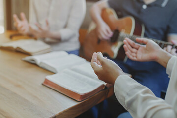 Christian young man group are playing guitar and sings a song from a Christian hymn book and the...