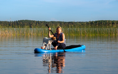 Fototapeta na wymiar Woman on paddle board with dog