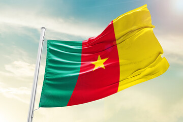 Cameroon national flag waving in beautiful clouds.