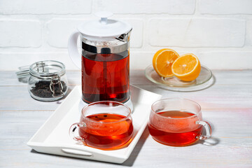 fresh black tea with lemon brewed in a French press, top view