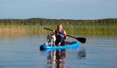 Woman on paddle board with dog 