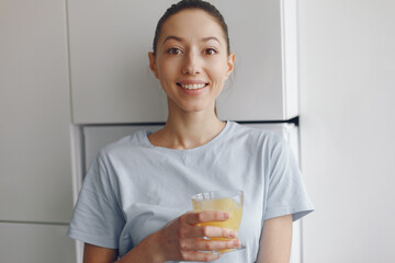 Beautiful girl at home with oranhe juice