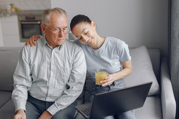 Obraz premium Girl teaching her grandfather how to use a laptop