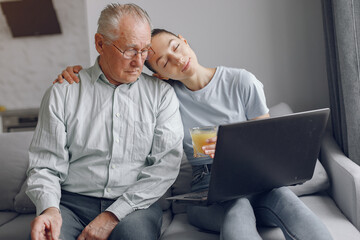 Girl teaching her grandfather how to use a laptop