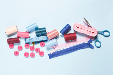 Sewing items from above. Flat lay composition with sewing accessories on light color background. Items for sewing, Sewing clothes, measuring tape, tailoring scissors, threads, buttons and needles
