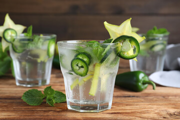 Spicy cocktail with jalapeno, carambola and mint on wooden table